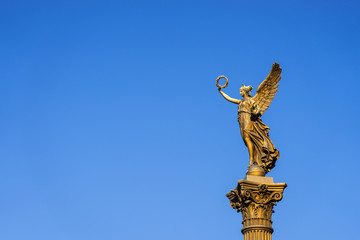 Obraz premium Gold lady monument on a blue sky background, Prague, horizontal