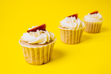 Cakes with white cream and strawberry filling on a yellow background. Baking and sweets.