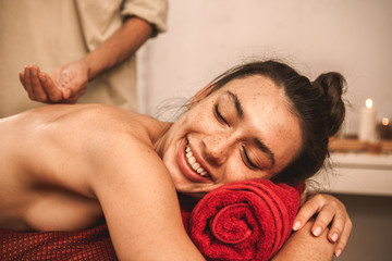 Alternative Medicine. Therapist healing doing ayurvedic massage for woman close-up lying laughing cheerful