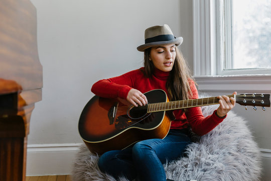 Beautiful Young Teenager Singing and Playing Guitar at Home