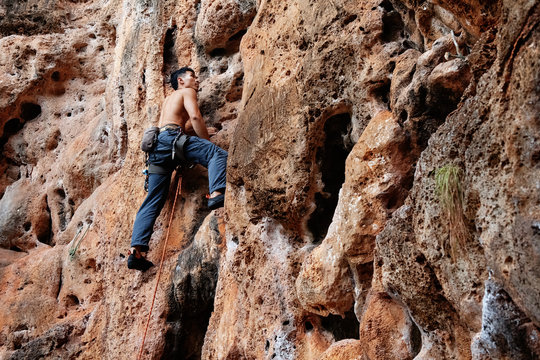 Sportive climber on rough rock