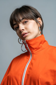 Cool young brunette in earrings wearing jacket