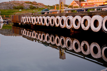 Reflection of a quay wall with white tyres