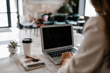 Crop woman using laptop in cafe