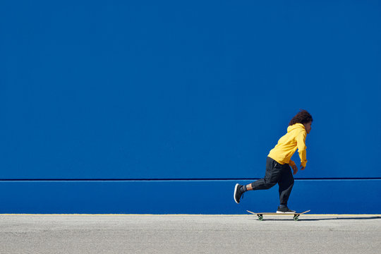 Ethnic man on skateboard on street