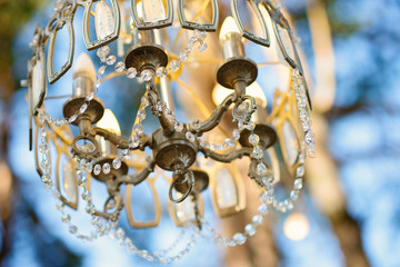 Beautiful crystal chandelier in the forest. Boho style party decor.