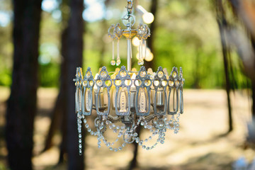 Beautiful crystal chandelier in the forest. Boho style party decor.