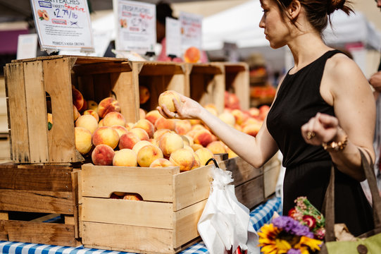 Woman Selecting Peaches At Farmers Market