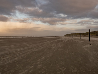 Norderney, Germany. 7 December 2019. Sandy beach on the North Sea coast on a windy winter afternoon in warm light.