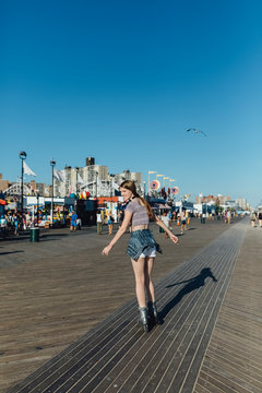 Smiling Young Caucasian Woman Skating with Roller Blades in Coney Island New York During a Beautiful Sunny Day . Lifestyle Stock Photo