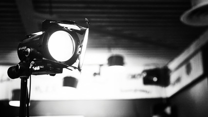 Dramatic black and white shot of a professional studio light in action. Focus on the beam. 