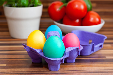 Fototapeta na wymiar Purple egg container with multicolored Easter eggs.