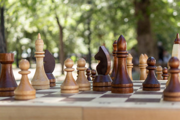 Chess is placed on the board. The game is on the street. sunny day