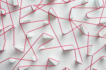 Interweaving red strings on white background
