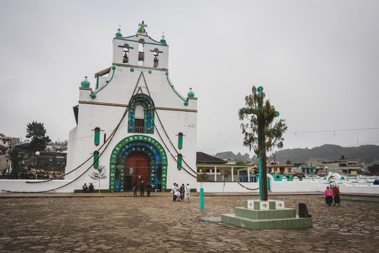San Juan Chamula church in the village of San Juan, just above the San Cristobal de las Casas. Overcast day, with cross visible in the foreground.