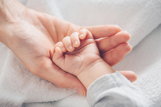 Close-up baby hand on mother's hands
