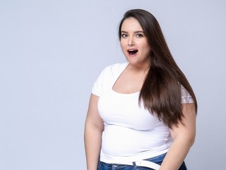 Shocked Plus Size Model with long hair posing in studio. eyes w