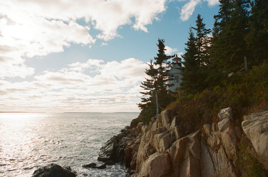 The sun breaks through scattered clouds on the new England coastline