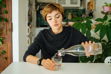 Young person filling glass of drink