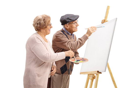 Senior man and woman painting with brushes on a canvas