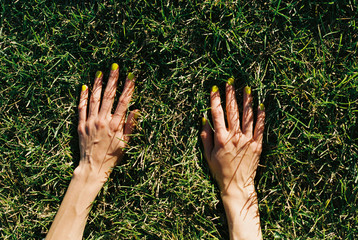 Young woman touches green grass