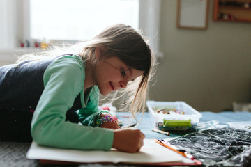 child writes letter and draws picture for dad