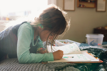 child writes letter and draws picture for dad