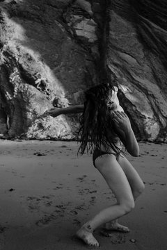 young woman feeling totally free dancing naked on the beach
