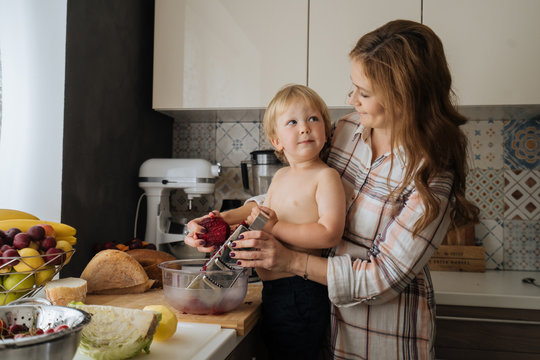 Mother and son grating vegetable and looking at each other