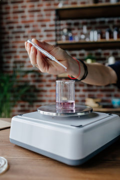 Perfumer mixing ingredients on scales