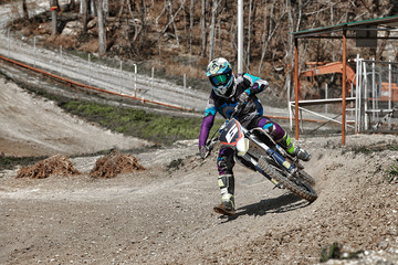 Close-up of mountain motocross race in dirt track in day time. Concept focus of during an...