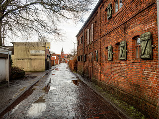 Norden, Germany. 8 December 2019. Red brick buildings on an abandoned factory yard on a rainy day.