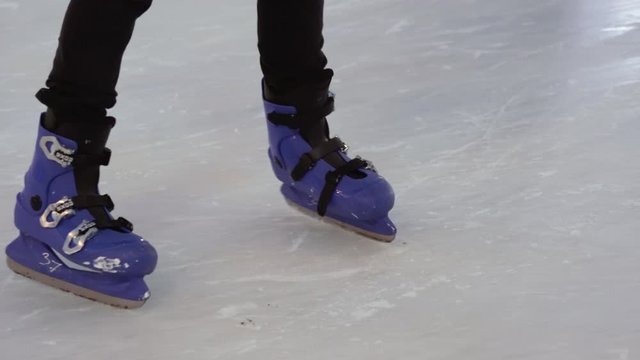 Man and woman riding in the skate together on the ice rink. Legs close up