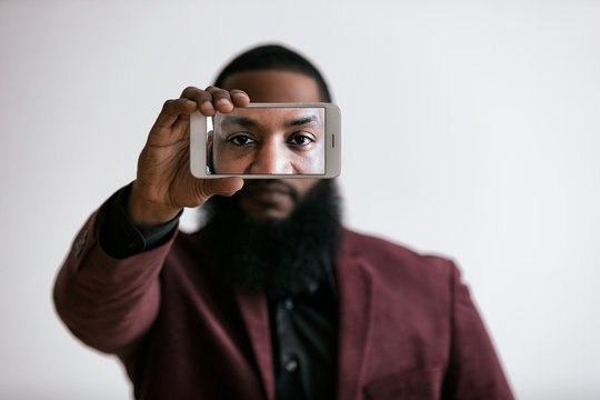African American Male Holds Cell Phone In Front Of Eyes