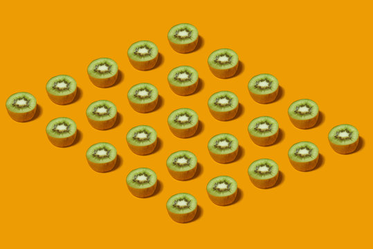 Pattern of fresh kiwi slices on yellow background