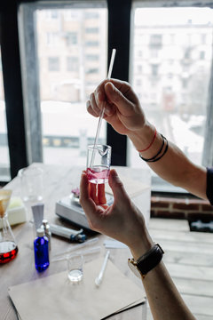 Perfumer mixing liquids in flask