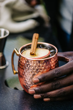 Mans hand touching an Apple Cider Moscow Mule Mug