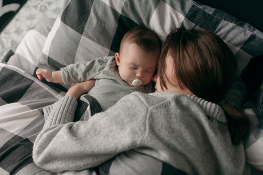 mom and baby sleeping on the bed hugging
