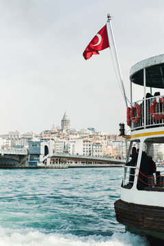 Boat with Turkish flag on water near city.