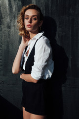 portrait of a beautiful fashionable blonde woman in black shorts white blouse