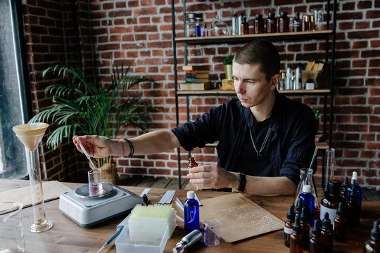 Perfumer mixing ingredients at table