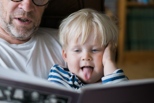 Grandfather reading a book for grandson