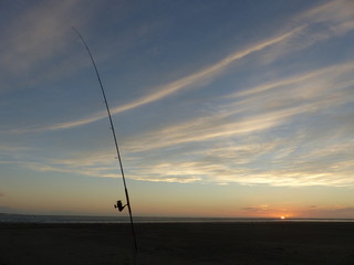 Surf casting fishing rod on Foxton beach at sunset in New Zealand