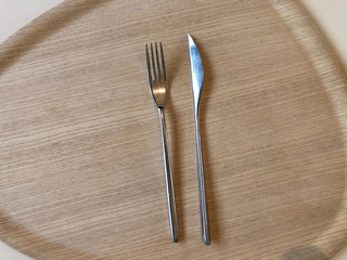 fork and knife on wooden tray