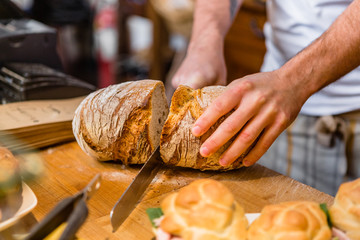 Baker Cutting Fresh Bread Loaf in a Bakery