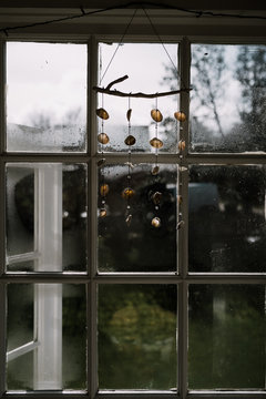A mobile made of seashells, hanging in a window