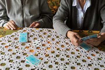 Anonymous senior couple playing card game