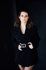 Portrait of a beautiful fashionable brunette woman in black tights and jacket style