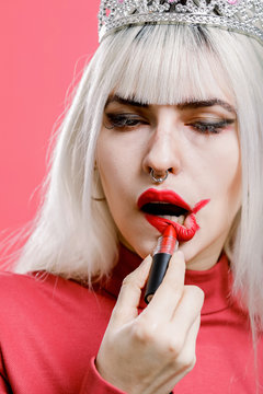 Shocked princess applying lipstick