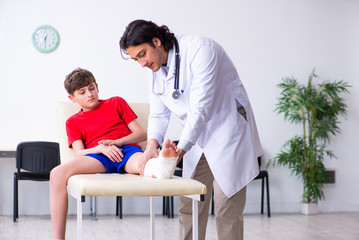 Leg injured boy visiting young doctor traumatologist